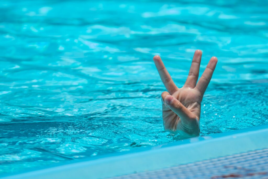 Fingers holding 3 from a pool.