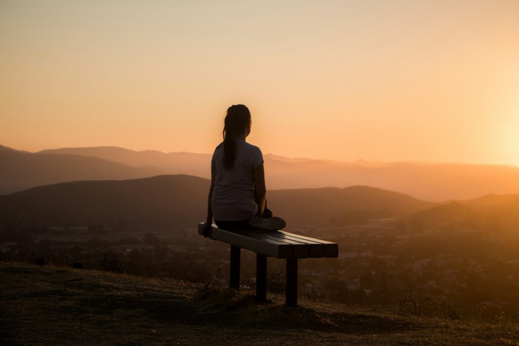 A women on a bench looking out the sight.